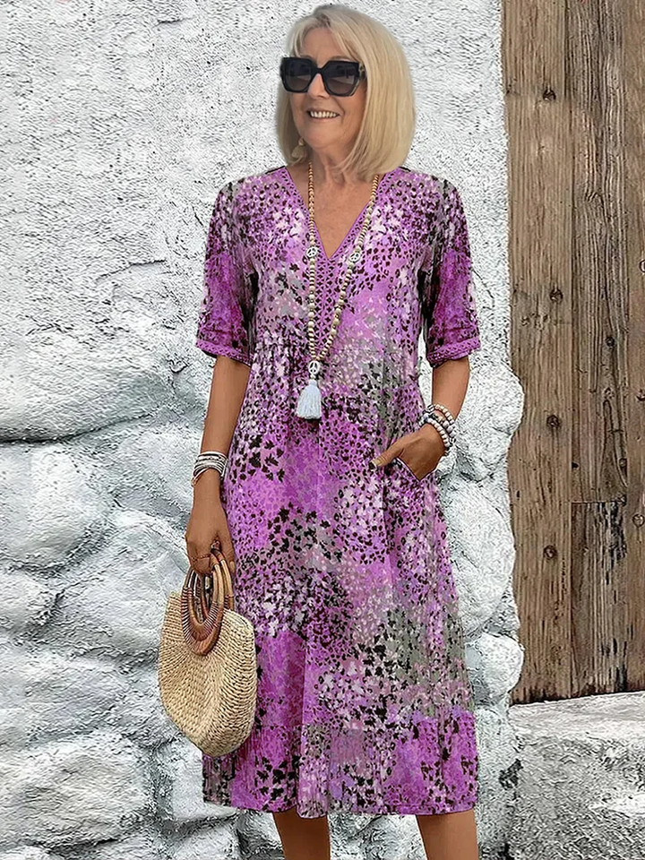 Model trägt sommerliches Damen Blumen Midikleid mit V-Ausschnitt und fließendem Rock.