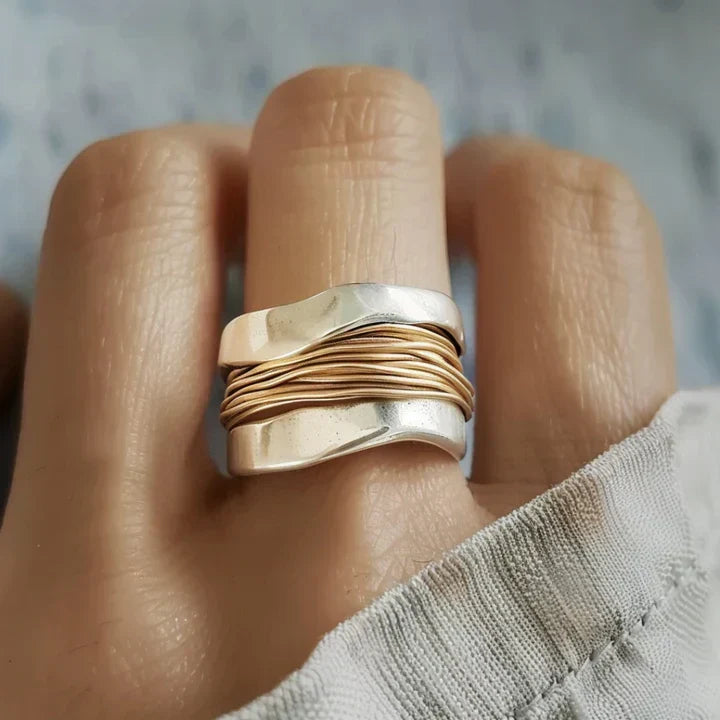 Eleganter Damen Silberring mit Goldakzenten, modernes Wickeldesign. Zeitloser Fingerschmuck für Frauen.