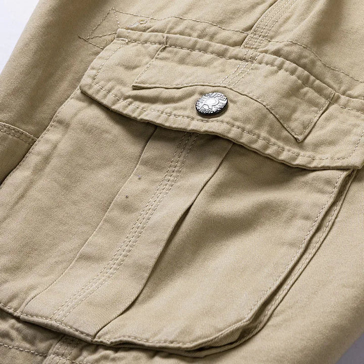 Nahaufnahme der strapazierfähigen Herren Cargo-Shorts in Khaki, zeigt Taschendetails und robuste Nähte.