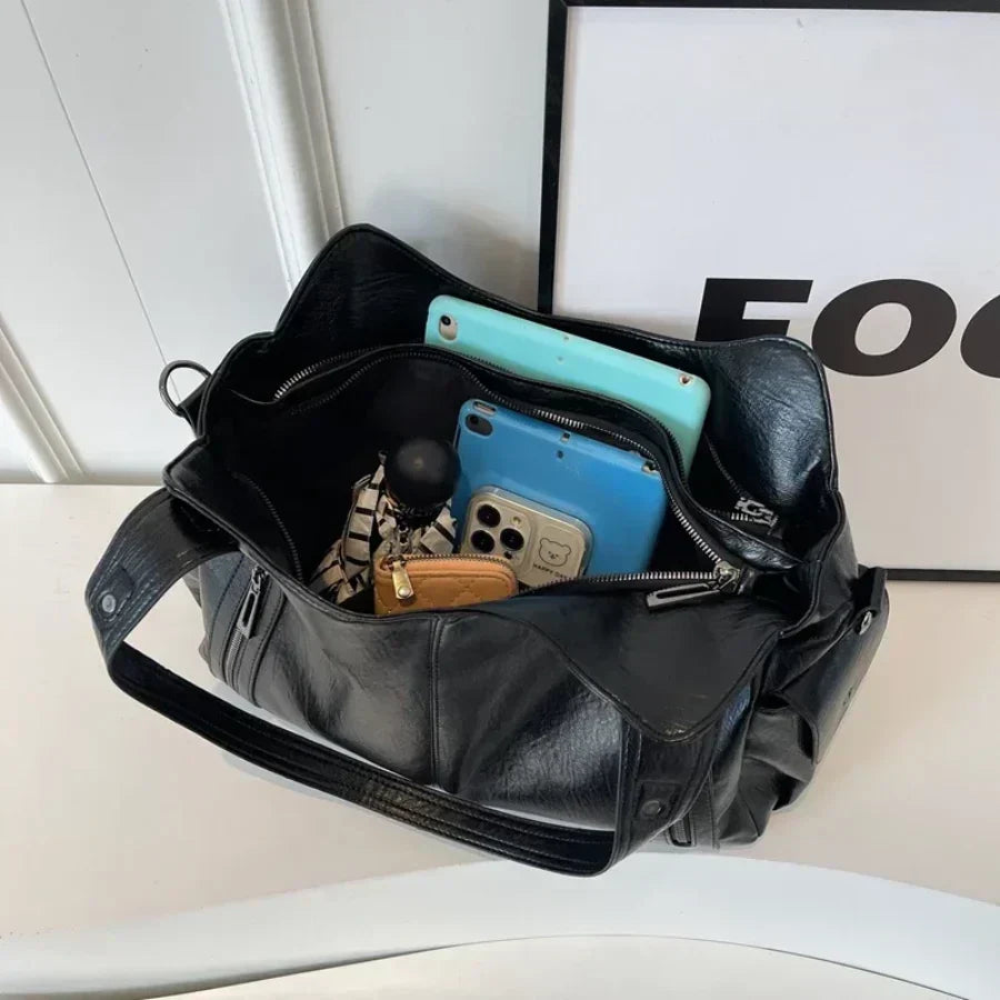 Schwarze Reisetasche für Damen mit Schultergurt. Großes Hauptfach für Kleidung & Essentials.