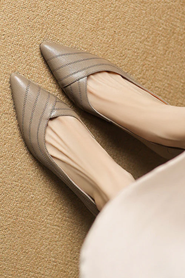 Dame trägt schwarze Business Pumps mit spitzem Absatz, modisch & komfortabel den ganzen Tag.