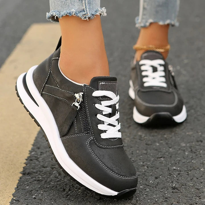 Seitenansicht des grauen Damen Sneakers: Komfortabler Schnürschuh mit praktischem Reißverschluss.