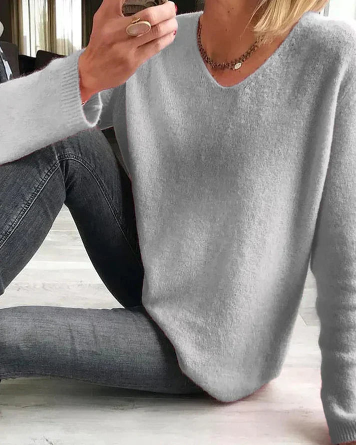 Frau trägt casual rosa Damenpullover "Sophie" mit V-Ausschnitt. Komfortable Herbst/Frühling Mode.