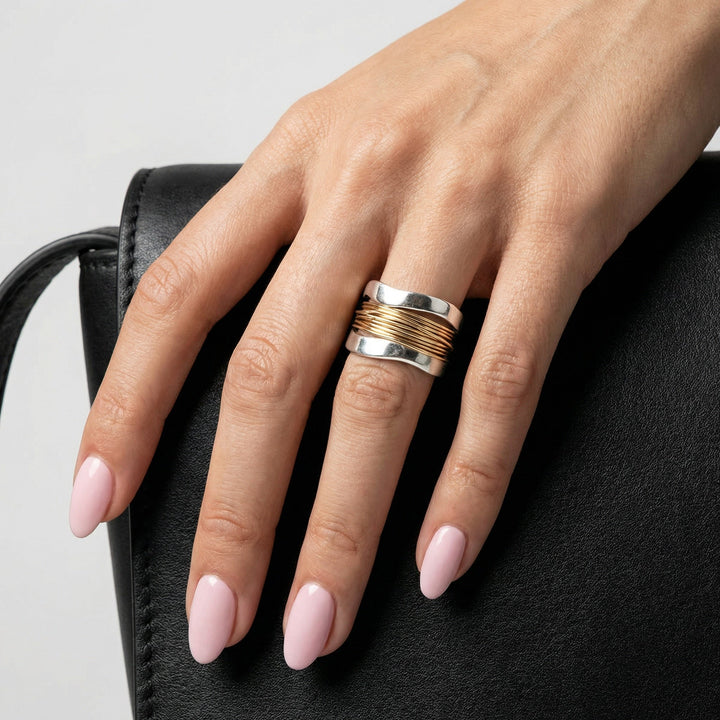 Moderner Damen Wickelring aus Silber mit glänzenden Goldakzenten. Stilvolles Accessoire für jeden Anlass.