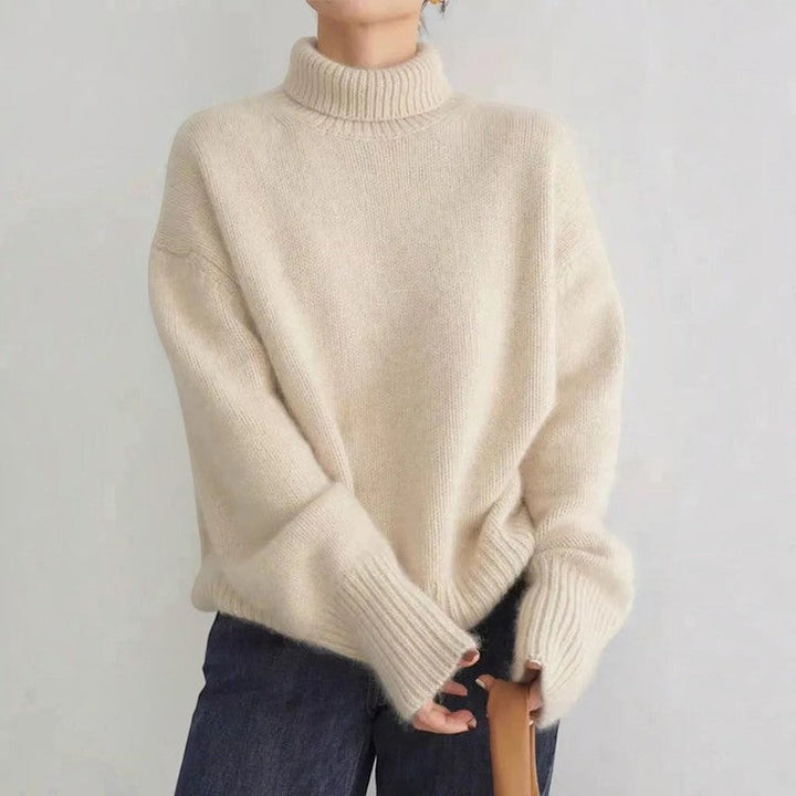 Detailansicht: Gerippter Rollkragen und Ärmelbündchen an einem bequemen Damen Strickpullover in Beige.