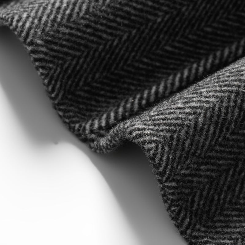 Nahaufnahme des Fischgrätmusters: Detailansicht des hochwertigen Stoffes eines Herren Blazers. Struktur & Qualität.