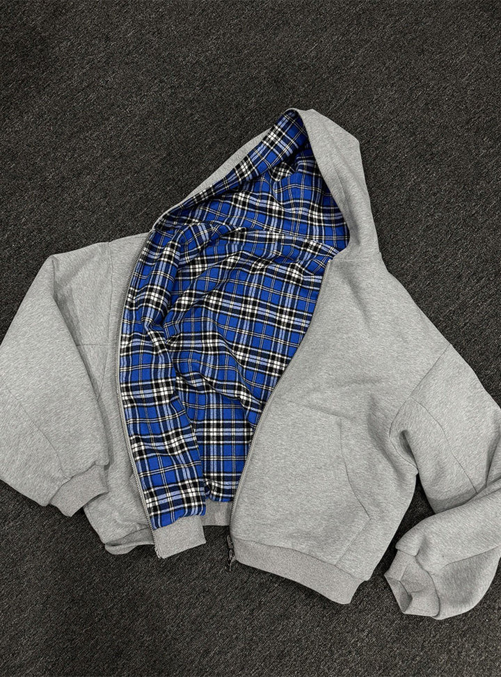 Detail: Offener Reißverschluss zeigt das karierte Futter des gepolsterten Herren Hoodies. Casual Style.