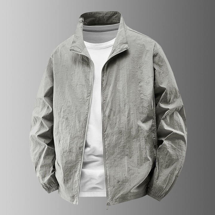 Mann trägt elegante, winddichte Herren Übergangsjacke in urbaner Umgebung. Ideal für Frühling & Herbst.