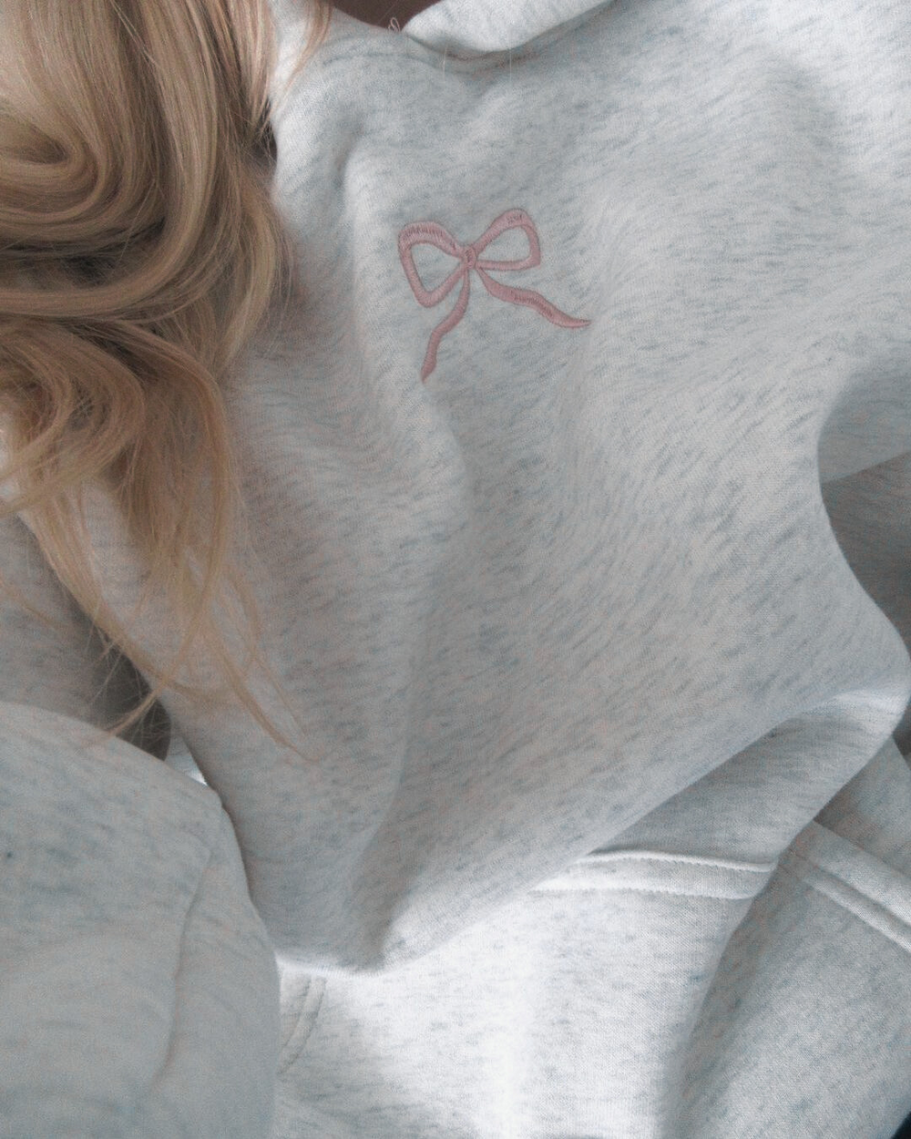 Stilvoller Damen Kapuzenpullover mit femininer rosa Schleife. Gemütlicher Regular Fit Hoodie für Damen im Alltag.