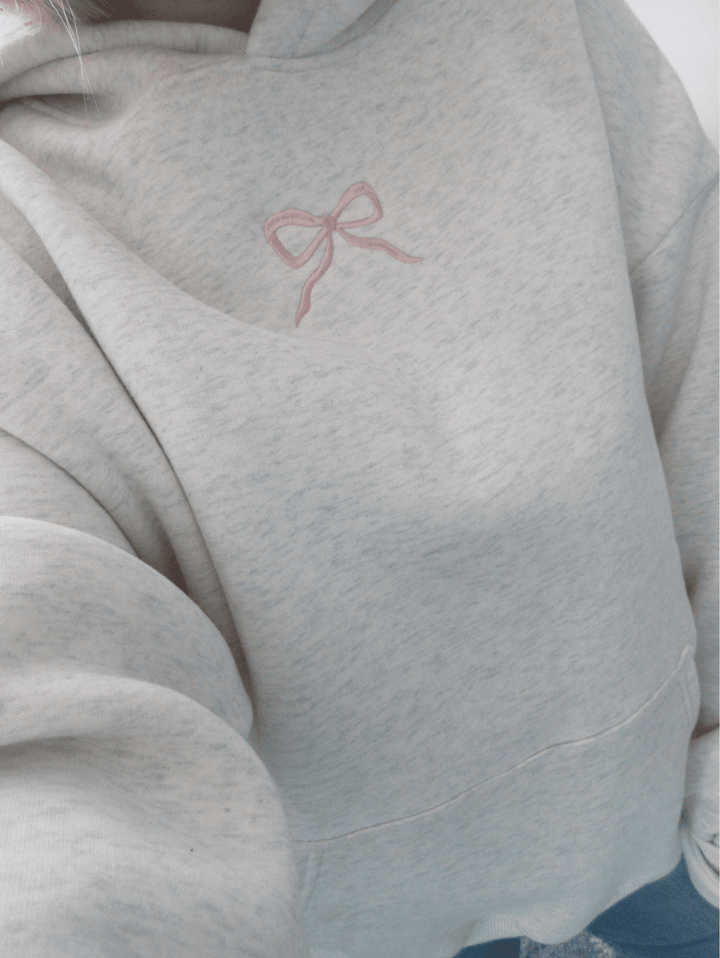 Gemütlicher Damen Hoodie Elodie in Weiß, mit Kapuze und süßem Schleifen-Detail. Ideal für kalte Tage.