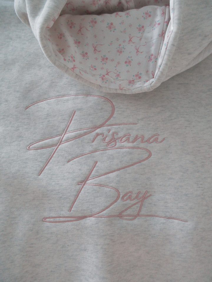 Damen Hoodie Elodie, weiß, mit Schleifenmotiv. Gemütlicher Kapuzenpullover für Freizeit & Alltag.