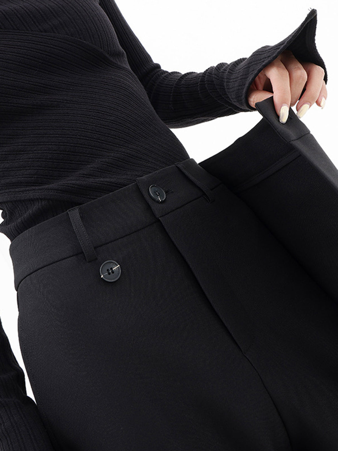 Frau trägt schwarze Baggy-Hose im Streetwear-Look, modisch und locker. Weite Freizeithose mit urbanem Flair.
