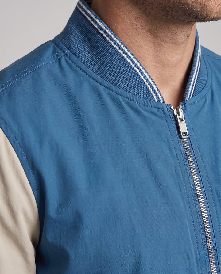 Sportliche Herren College Bomberjacke in Blau, Detailansicht des Stehkragens und der robusten Reißverschlussleiste.
