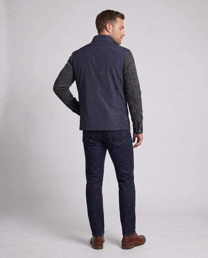 Mann trägt eine elegante Herren Hybridjacke beim Spaziergang, unterstreicht urbanen und flexiblen Stil.