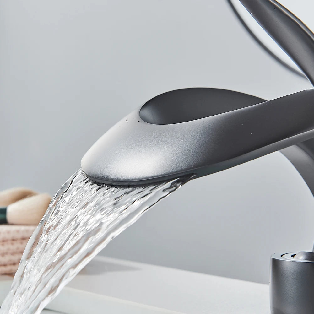 Detailansicht: Moderner Wasserfall-Auslauf einer Messing Waschtischarmatur.