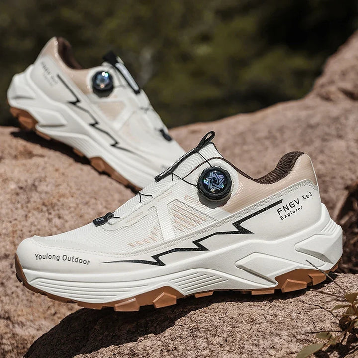Mann trägt robuste Herren Outdoor Wanderschuhe mit Drehverschluss beim Wandern auf einem felsigen Trail.