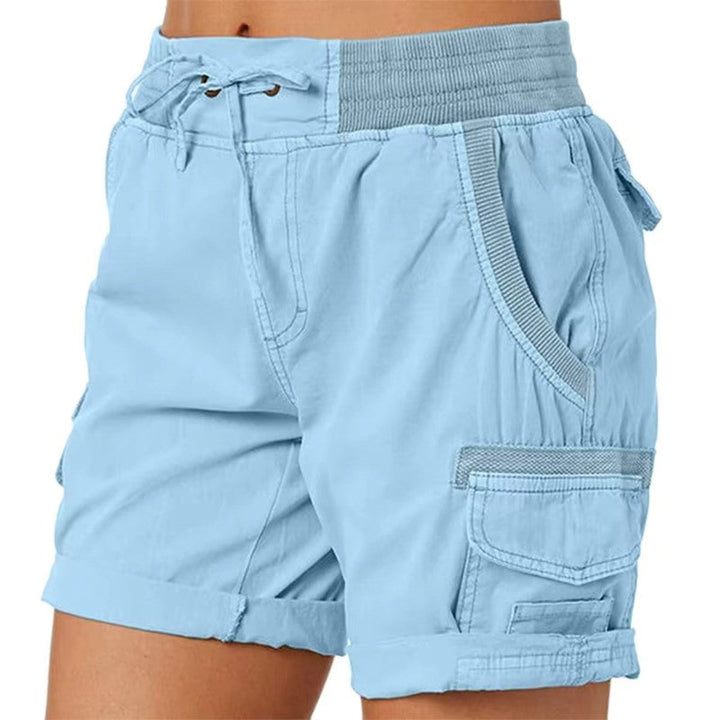 Dame trägt hellblaue Casual Shorts mit Seitentaschen beim Spaziergang. Bequeme Freizeit Shorts für den Sommer.