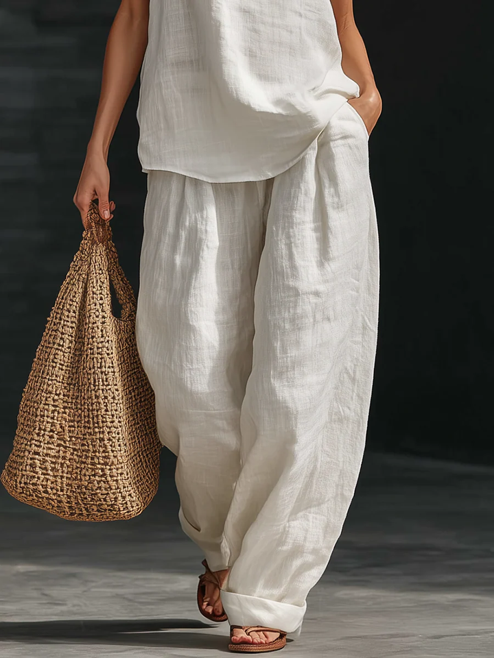 Modisches Damen Sommer Outfit: Elegantes weißes Zweiteiler Set mit Top und Hose. Ideal für entspannte Sommertage.