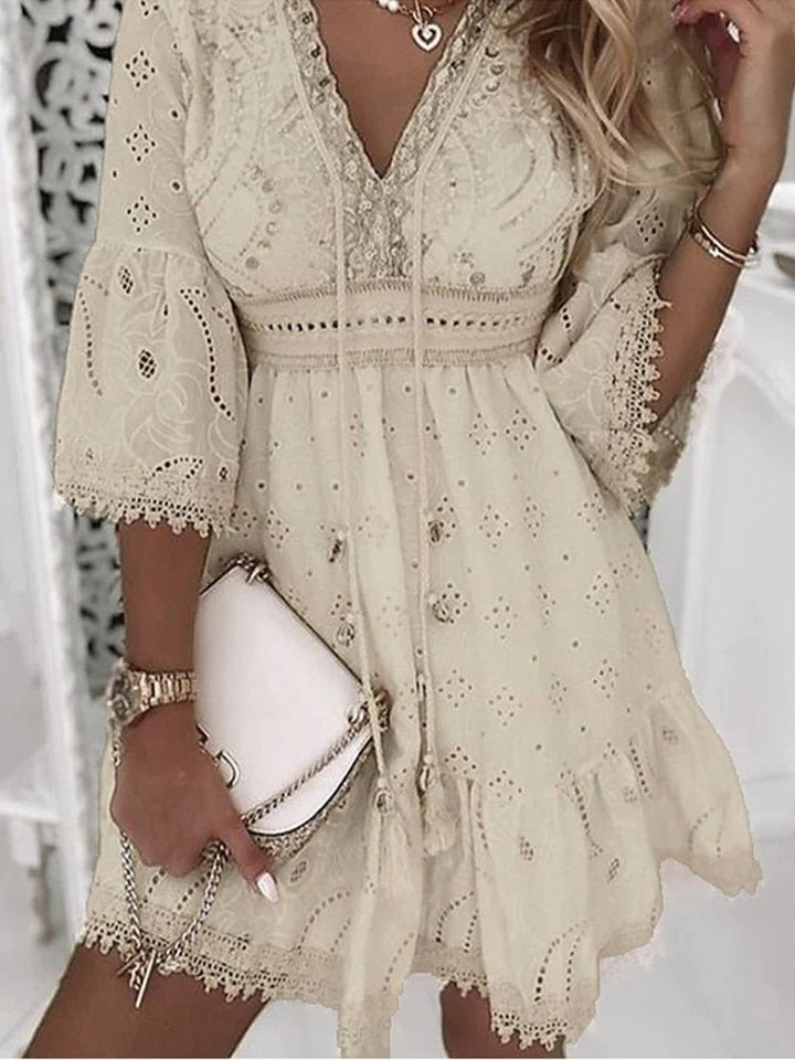 Beiges Damen Boho Minikleid mit V-Ausschnitt, leicht und luftig, perfekt als Sommer- oder Strandkleid.