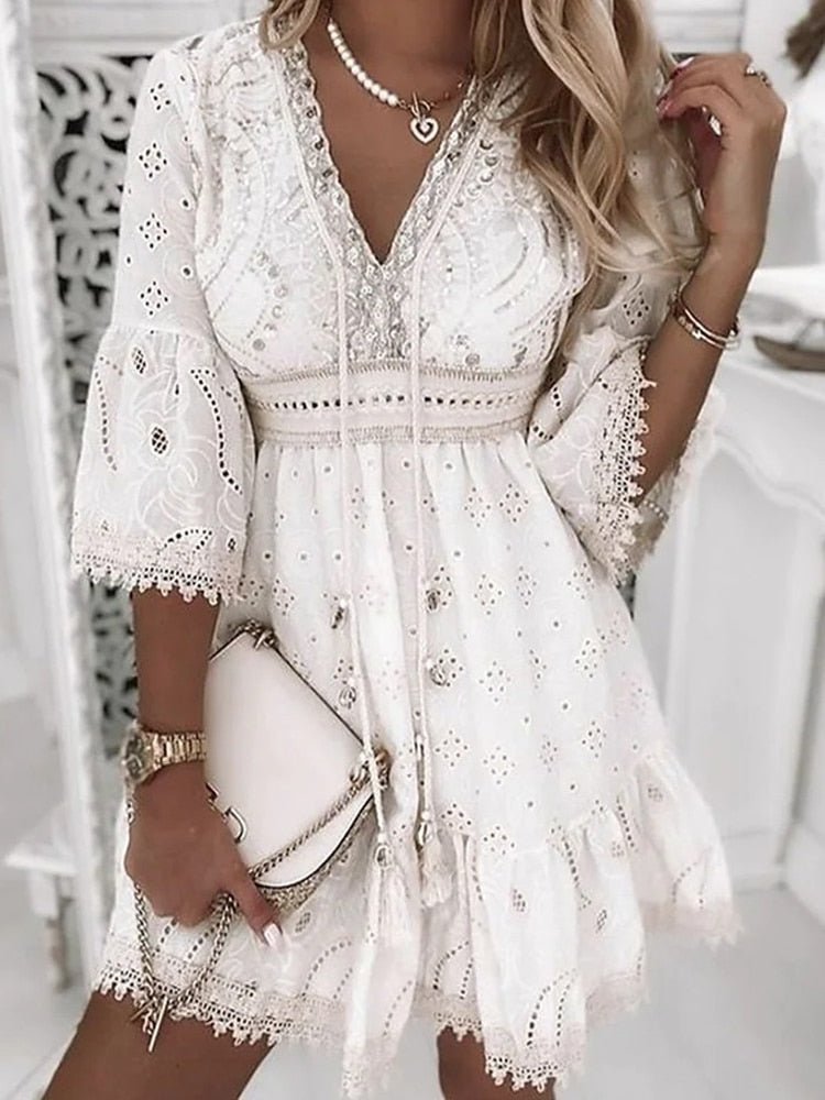 Kurzes weißes Damen Freizeitkleid im Boho-Stil mit V-Ausschnitt, Lochmuster und Lagenlook für den Sommer.