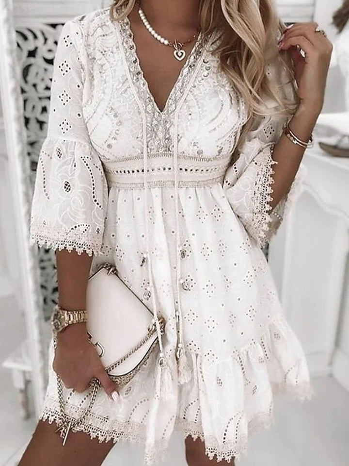 Kurzes weißes Damen Freizeitkleid im Boho-Stil mit V-Ausschnitt, Lochmuster und Lagenlook für den Sommer.