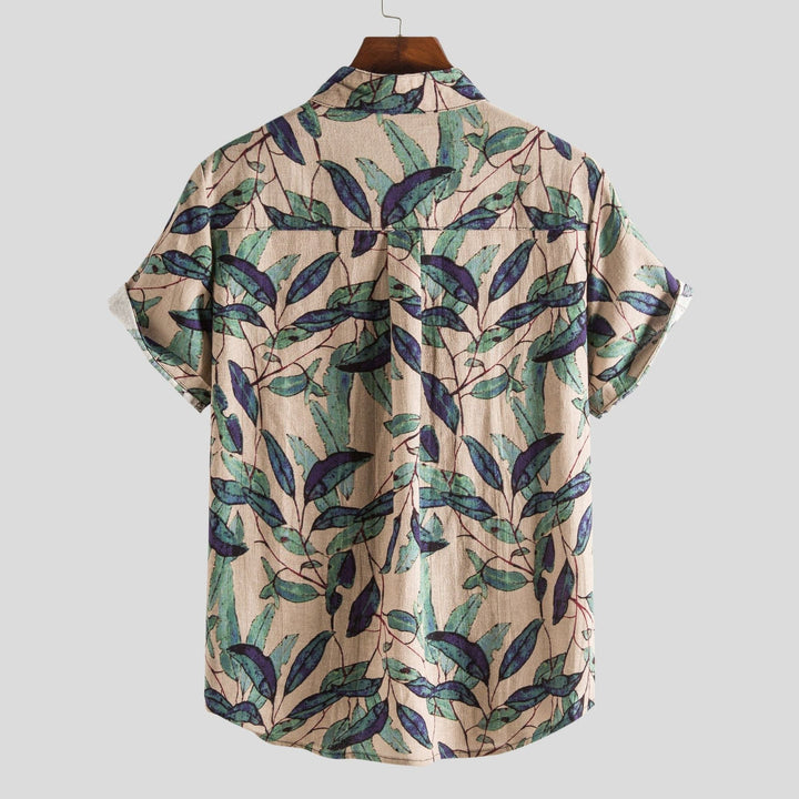 Mann trägt lässiges Herren-Sommerhemd. Buntes Kurzarmhemd mit Muster, perfekt für Strand, Urlaub oder Freizeitlook.