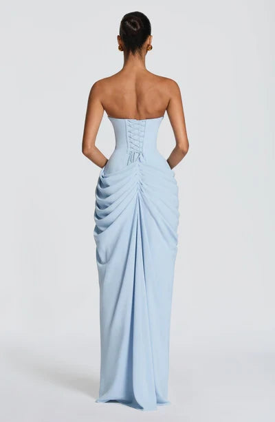 Modell trägt elegantes trägerloses Korsett Maxikleid mit fließendem Rock & Beinschlitz.
