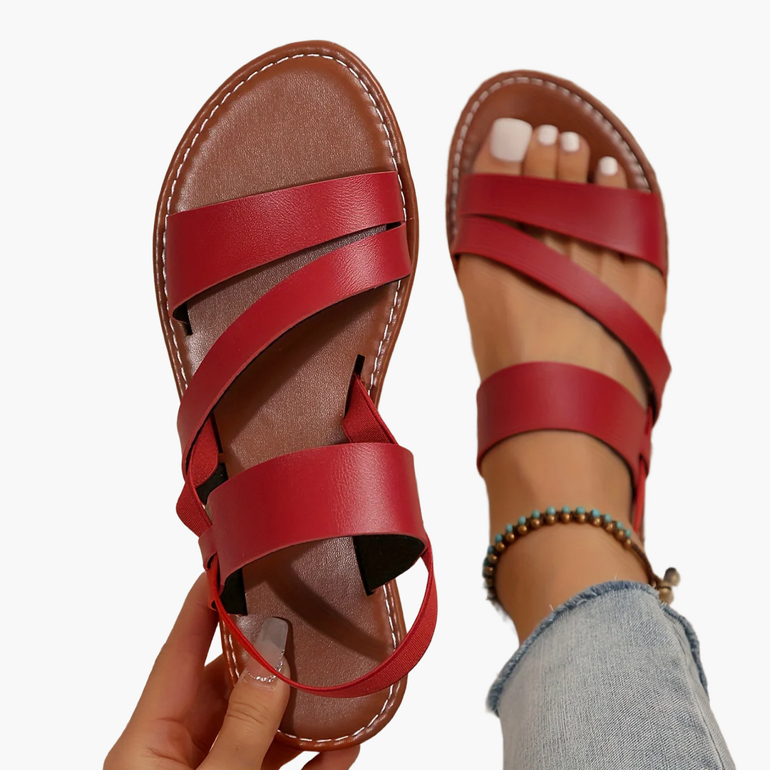 Leichte Damensandalen, schwarze Kreuzriemen, bequeme flache Sohle, perfekt für warme Tage.