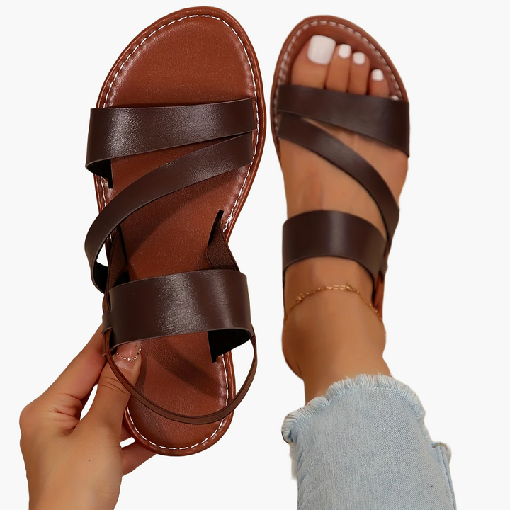 Elegante Kreuzriemen-Sandale für Damen, schwarz, flache Sohle, offene Zehen, modischer Look.