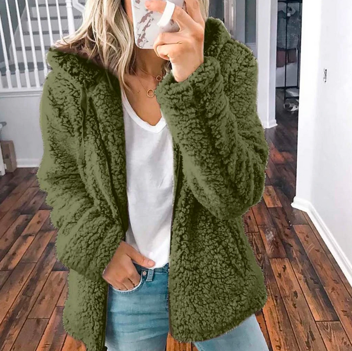 Frau spaziert in modischer Oversized-Übergangsjacke, kuschelig & stilvoll für herbstliche Spaziergänge.