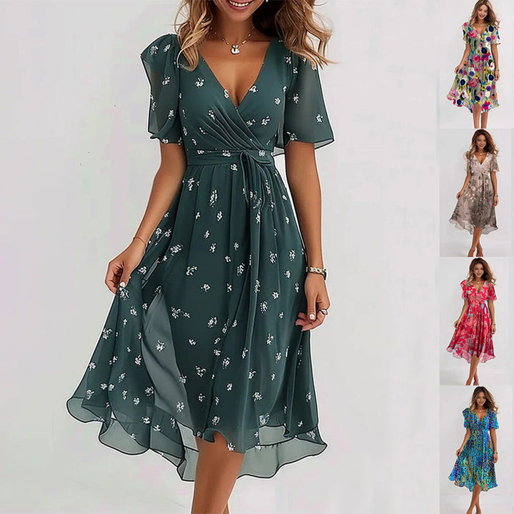 Dame im eleganten Sommer Wickelkleid mit Muster. Figurfreundliches Freizeitkleid mit V-Ausschnitt & Flügelärmeln.