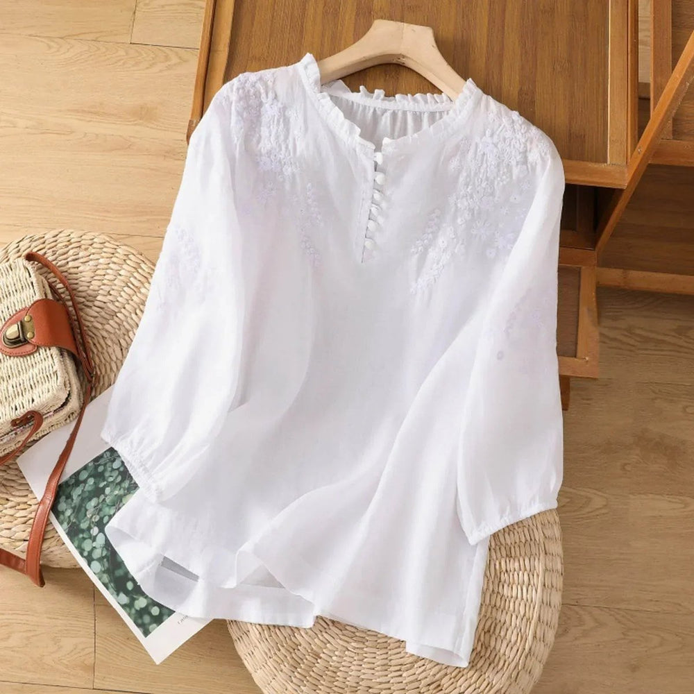 Nahaufnahme einer bestickten Damen Sommerbluse im Boho Stil mit zarten Rüschen am Kragen, ideal für Freizeit.