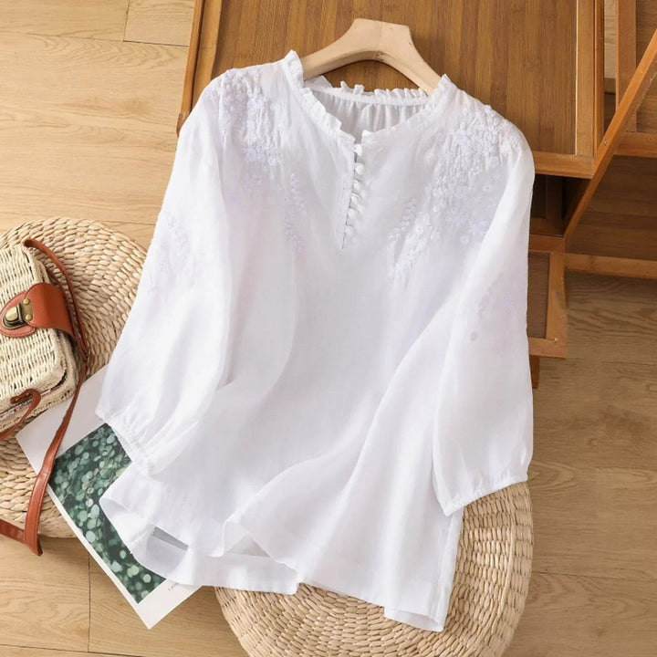 Nahaufnahme einer bestickten Damen Sommerbluse im Boho Stil mit zarten Rüschen am Kragen, ideal für Freizeit.