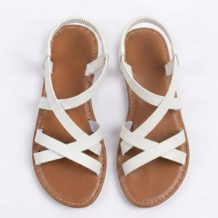 Nahaufnahme flacher Damensandalen mit stilvollen Riemchen & Knöchelriemen. Klassisches Design für den Sommer.