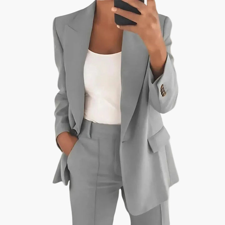 Damen Hosenanzug in Business-Umgebung. Klassischer, eleganter Look in Dunkelblau für selbstbewusste Frauen im Berufsleben. Büromode.