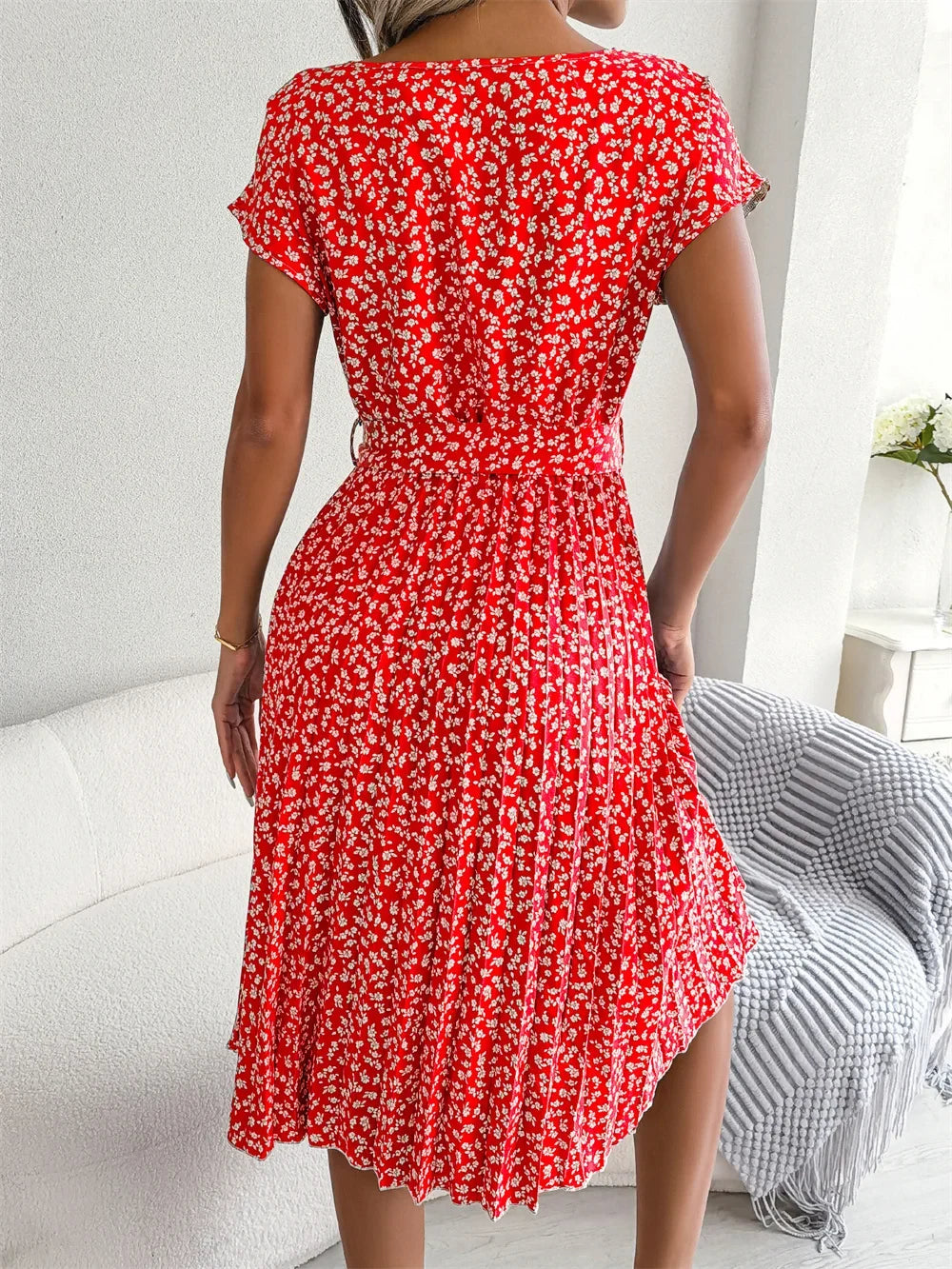 Kurzärmeliges Damenkleid in A-Linie mit zartem Blumenmuster und plissiertem Stoff.