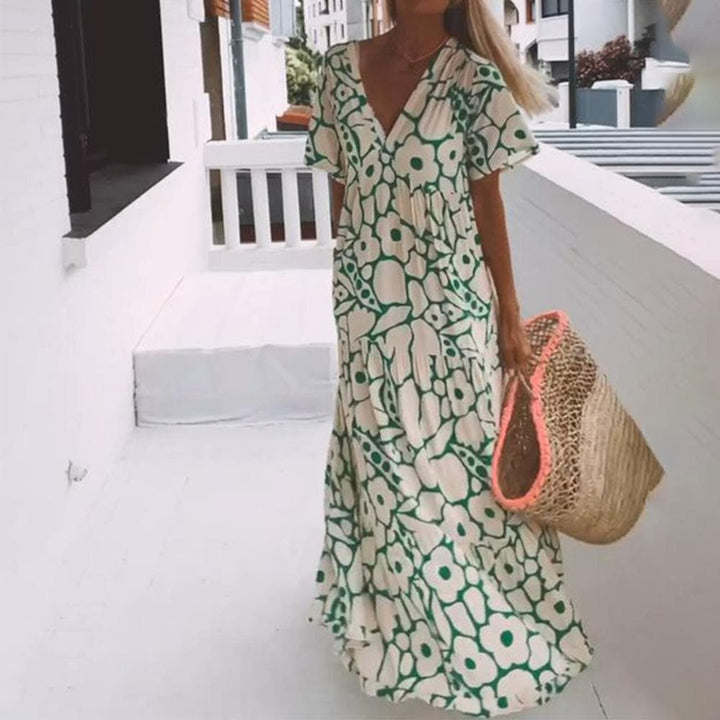 Geblümtes Damen Boho Maxikleid für sonnige Tage. Langes Sommerkleid mit V-Ausschnitt und zarten Flügelärmeln.