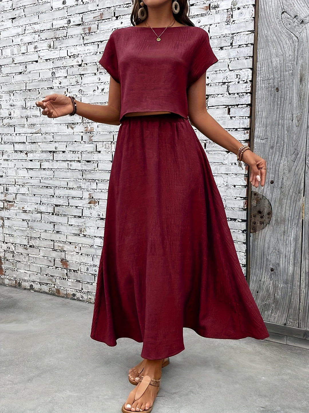 Elegantes schwarzes Damen-Outfit: Crop Top mit weitem Maxirock, ideal für die Sommer-Kollektion.