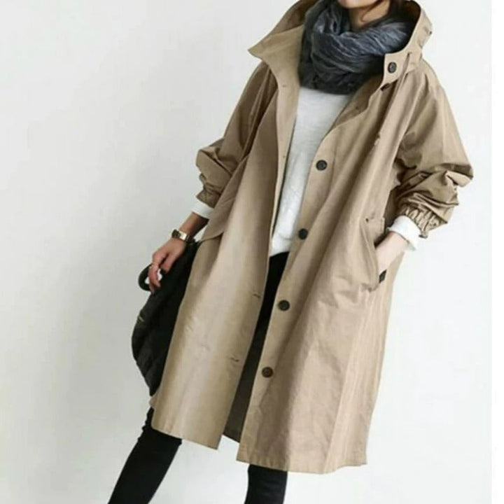 Dame trägt eleganten, wasserabweisenden Trenchcoat beim Spaziergang. Ideal für Übergangsjacke und Freizeit.
