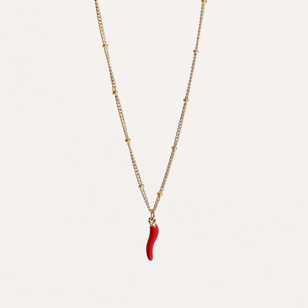 Nahaufnahme: Goldkette mit detailreichem roten Emaille-Chili-Anhänger. Perfekt für Damen.