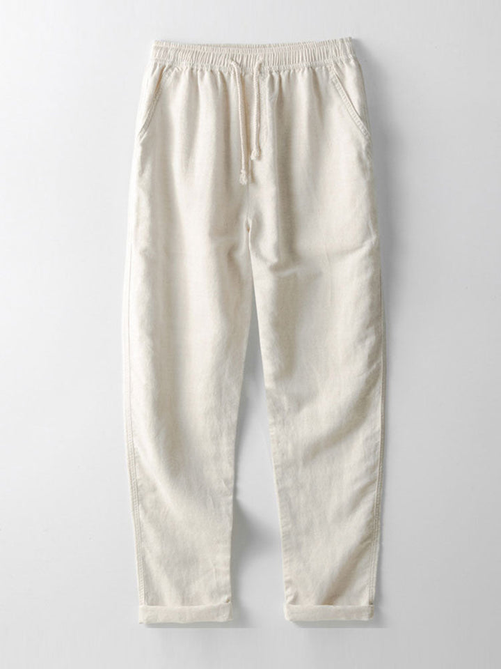 Mann in Leinen-Freizeitanzug mit Strohhut & Sandalen. Komplettes Sommer-Outfit, atmungsaktiv und lässig.