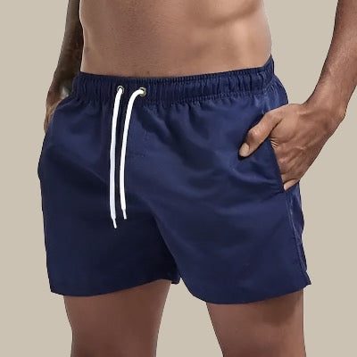 Herren Slim Fit Badehose mit elastischem Bund, bereit für den Tag am Strand mit passendem Zubehör.