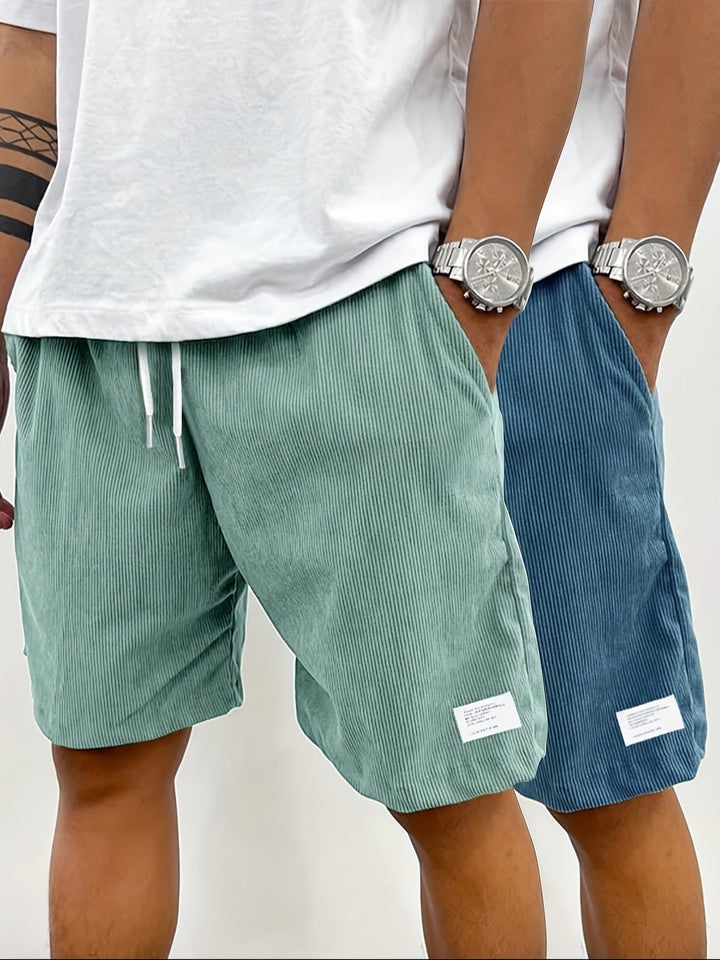 Model trägt moderne Herren Streetwear Shorts, vielseitig kombinierbar und sehr bequem.