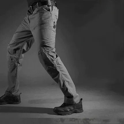Mann trägt bequeme TitanX taktische Hose beim Wandern. Vielseitige Outdoor- & Arbeitshose für Herren.