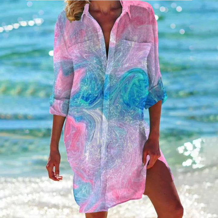 Dame trägt buntes tropisches Hemdkleid, entspannt am Strand, perfekt für Sommer & Freizeit.