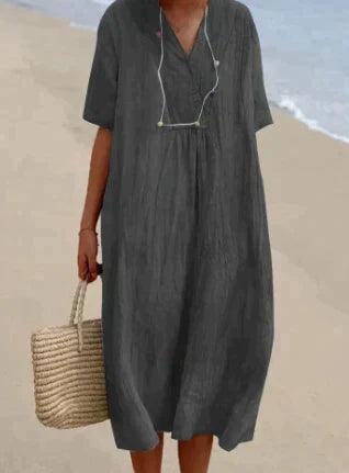 Stilvolles Sommerkleid für Damen mit V-Ausschnitt & kurzen Ärmeln. Luftiges Design für heiße Tage & den Strand.