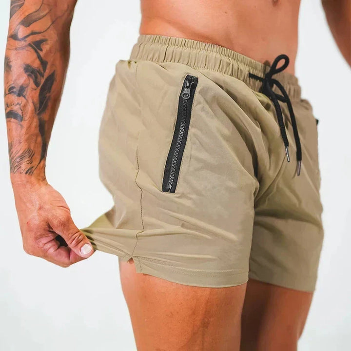 Mann trägt bequeme Herren Badeshorts am Strand, bereit für Schwimmen und Wassersport.